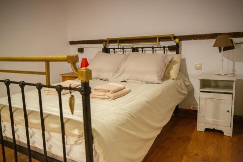 a bed with white sheets and pillows in a room at LA CASITA DE LA CORREDERA in Candeleda