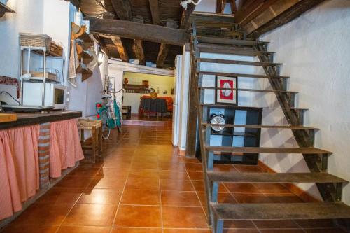 un couloir avec un escalier en colimaçon dans une maison dans l'établissement LA CASITA DE LA CORREDERA, à Candeleda