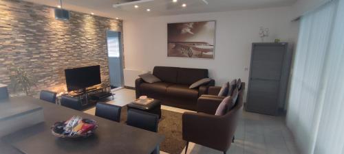 a living room with a couch and a table at Maas Chalet Aldeneik in Maaseik