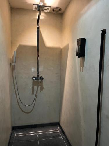 um chuveiro na casa de banho com uma mangueira na parede em Den Eijngel bed and breakfast em Boxtel
