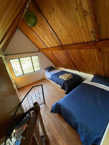 a attic bedroom with two beds and a window at Casa finca en Guateque Boyaca in Guateque