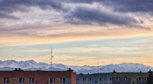 a building with a mountain range in the background at Apartament na wynajem in Nowy Targ