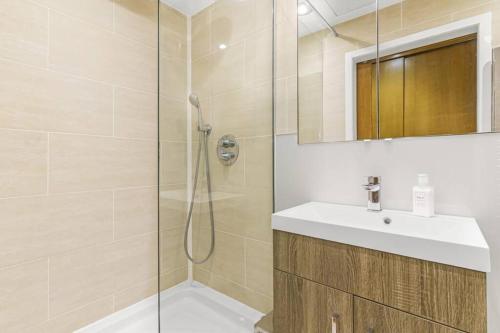 a bathroom with a shower and a sink and a mirror at Notting Hill 2BR Gem l Stylish Prime Apt in London