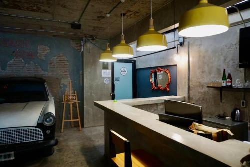 a bar with a car parked in a room with lights at Silom Soi 3 Hash Apartment hip and funky with rooftop view in Bangkok