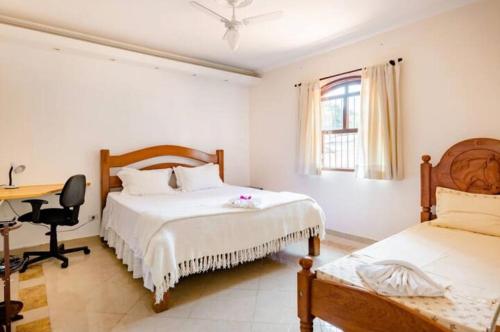 1 dormitorio con 2 camas y escritorio. en Quarto com / Bosque / Estoril / SJC, en São José dos Campos