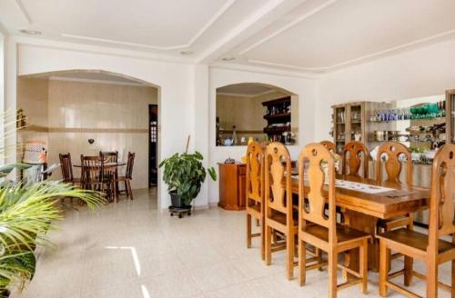 uma sala de jantar com uma mesa de madeira e cadeiras em Quarto com / Bosque / Estoril / SJC em São José dos Campos