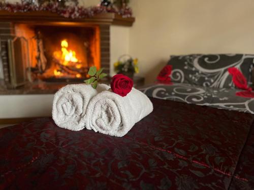 Una habitación con una cama con toallas y una rosa en La casa di Mary en Castiglion Fiorentino