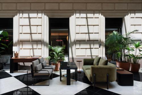 a lobby with chairs and tables and plants at Casa Lucia Member of Melia Collection in Buenos Aires