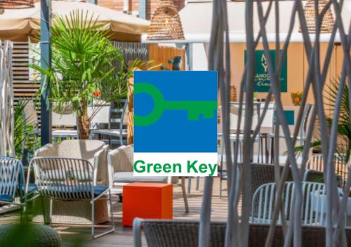 un cartello per una chiave verde in un patio con sedie di Mercure Toulouse Centre Saint-Georges a Tolosa