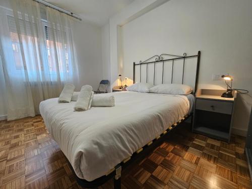 619A Moderno y acogedor apartamento في أوفِييذو: غرفة نوم بسرير كبير عليها شراشف ووسائد بيضاء