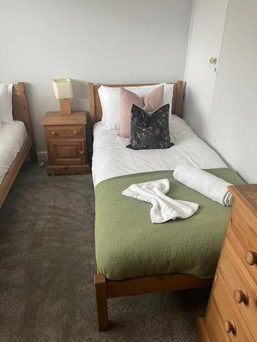 1 dormitorio con 1 cama con 2 toallas en Bonningtons - Charming 2 Bed Property In Brentwood, en Shenfield