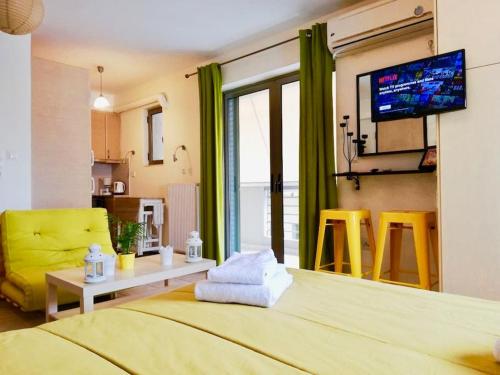 a room with a bed and a table and a tv at Superb Acropolis View From A Central Brand New Apt in Athens