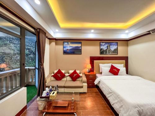 薩帕的住宿－自由沙巴酒店，一间卧室配有一张床、一张沙发和一个窗口