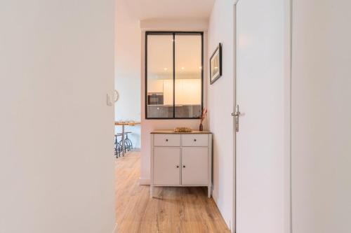 un couloir avec une armoire blanche et un miroir dans l'établissement Lille Hypercentre / Gares - Superbe T2 équipé, à Lille