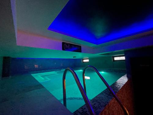 an indoor swimming pool with blue and green lights at Apartman Plavi bor in Zlatibor