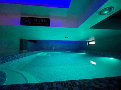 a swimming pool with green lights in a building at Apartman Plavi bor in Zlatibor
