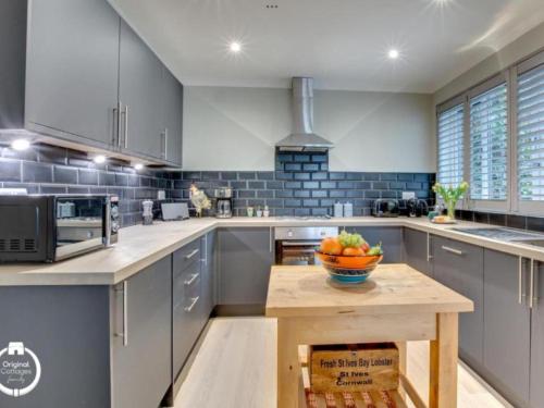 a kitchen with a bowl of fruit on a wooden table at The Heart of Rye in Rye