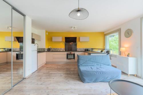 une grande cuisine avec un canapé bleu au milieu dans l'établissement Apartment near metro with parking & balconies, à Lille