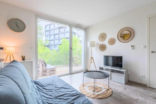 - un salon avec un canapé et une télévision dans l'établissement Apartment near metro with parking & balconies, à Lille