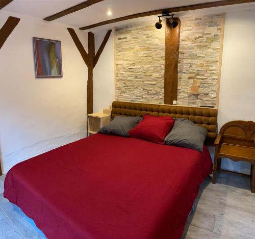 a bedroom with a large bed with a red blanket at La suite du Bûcheron in Laharie