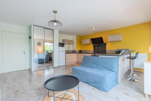 un salon avec un canapé bleu et une cuisine dans l'établissement Apartment near metro with parking & balconies, à Lille