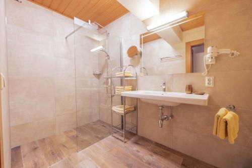 ein Bad mit einem Waschbecken und einer Dusche in der Unterkunft Appartement Christian in Maurach