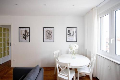 un salon blanc avec une table et des chaises blanches dans l'établissement Av REPUBLIQUE Design and cozy, à Aubervilliers