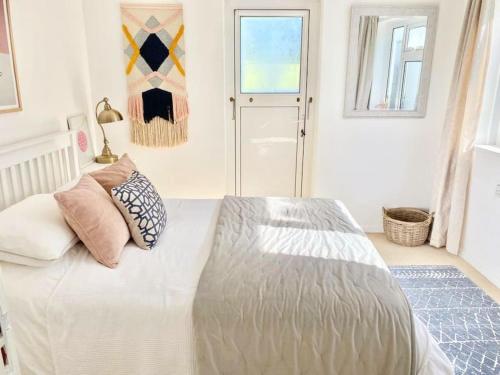 a bedroom with a large bed with pillows on it at Driftwood in Gurnard
