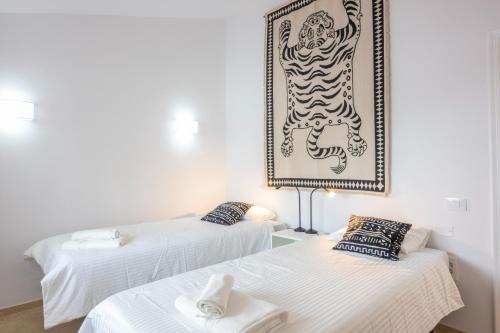 a room with two beds and a picture on the wall at Calala House with huge terrace in Candelaria