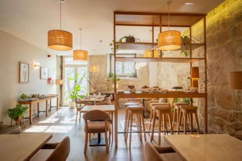 un restaurant avec des tables et des tabourets en bois dans l'établissement Memoria Porto FLH Hotels, à Porto