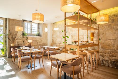 a restaurant with tables and chairs in a room at Memoria Porto FLH Hotels in Porto