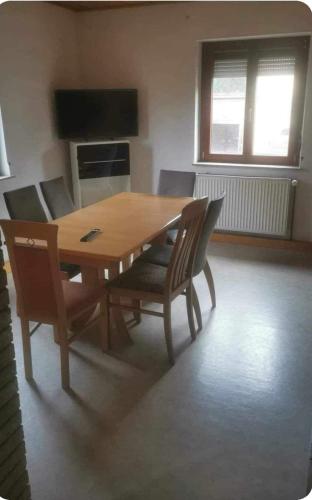 einen Holztisch und Stühle im Wohnzimmer in der Unterkunft Monteurzimmer rasic in Sachsenheim