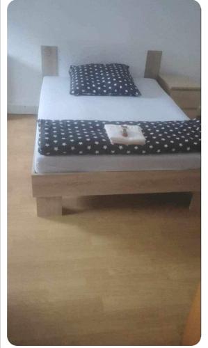1 cama con marco blanco y negro en Monteurzimmer rasic en Sachsenheim