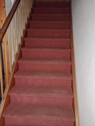 un escalier avec moquette rouge dans l'établissement Monteurzimmer rasic, à Sachsenheim