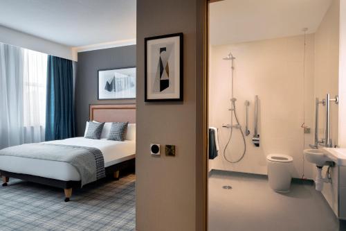 a bedroom with a bed and a bathroom at Leonardo Royal Hotel Edinburgh in Edinburgh