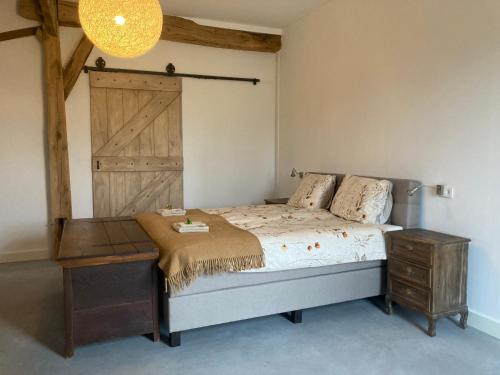 een slaapkamer met een bed en een houten deur bij Hoeve de Snippert in Groenlo