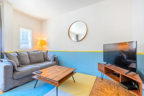 un salon avec un canapé et une télévision à écran plat dans l'établissement Functional flat in the heart of Old Lille., à Lille
