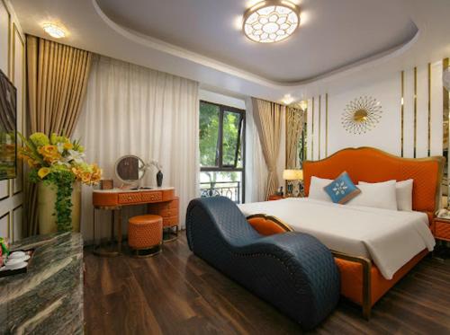 ein Schlafzimmer mit einem großen Bett und einem blauen Stuhl in der Unterkunft Bao Ngoc Hotel Linh Dam in Hanoi