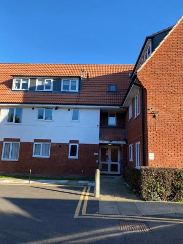 a red and white brick building with a street at Lovely 2 Bed flat close to South Woodham Ferrers station in Woodham Ferrers