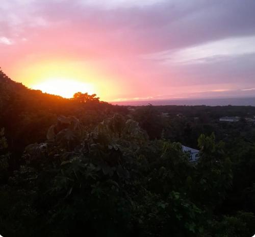 einen Sonnenuntergang von der Spitze eines Hügels in der Unterkunft Backra`s Villa in Port Antonio
