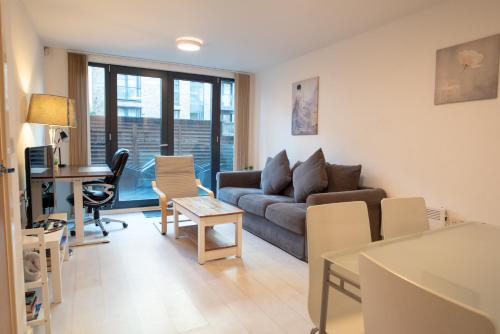 a living room with a couch and a desk at Two-Bedroom Luxury Apartment with Workspace, Free Parking & coffee in Birmingham