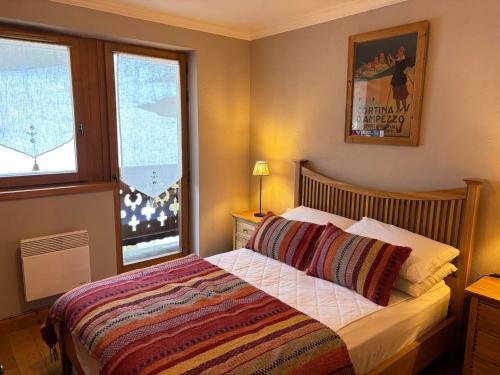 une chambre avec un lit et deux fenêtres dans l'établissement Appartement 3 chambres avec balcon, proche des pistes, parking, WiFi, TV avec Netflix et Amazon. - FR-1-623-79, aux Gets