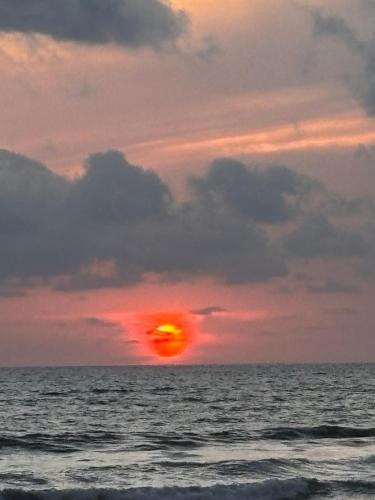 a sunset over the ocean with the sun setting at Villa Paraiso do Mar in Jacó