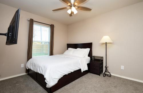 um quarto com uma cama e uma ventoinha de tecto em Downtown Elegance: 2-BR Home - San Angelo, Texas em San Angelo