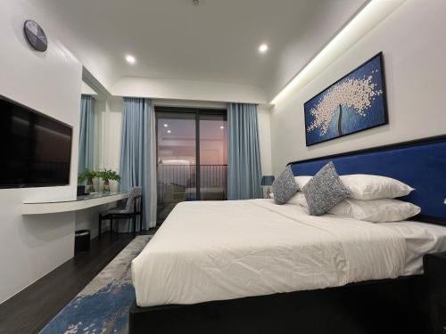 una camera con un grande letto e una televisione di Oscar Seaview Apartment a Phu Quoc