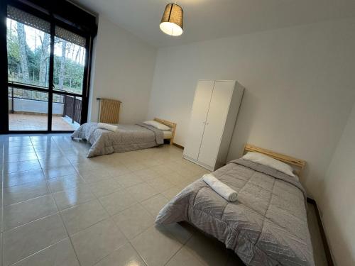 a bedroom with two beds and a large window at Volturno House2 in Rome