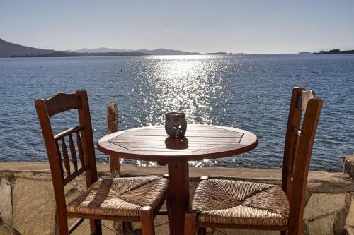 a table with two chairs and a vase on top of the water at Petalides Apartments in Parikia