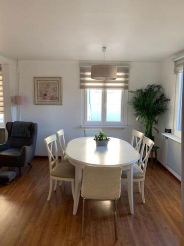 un salon avec une table et des chaises blanches dans l'établissement la Maison d'à coté de Strasbourg, à Illkirch-Graffenstaden