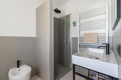 a white bathroom with a sink and a shower at Villa Rocco Country House in Ozzano Monferrato