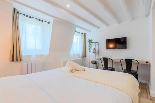 une chambre blanche avec un lit et un bureau dans l'établissement Lille center bright and functional studio, à Lille